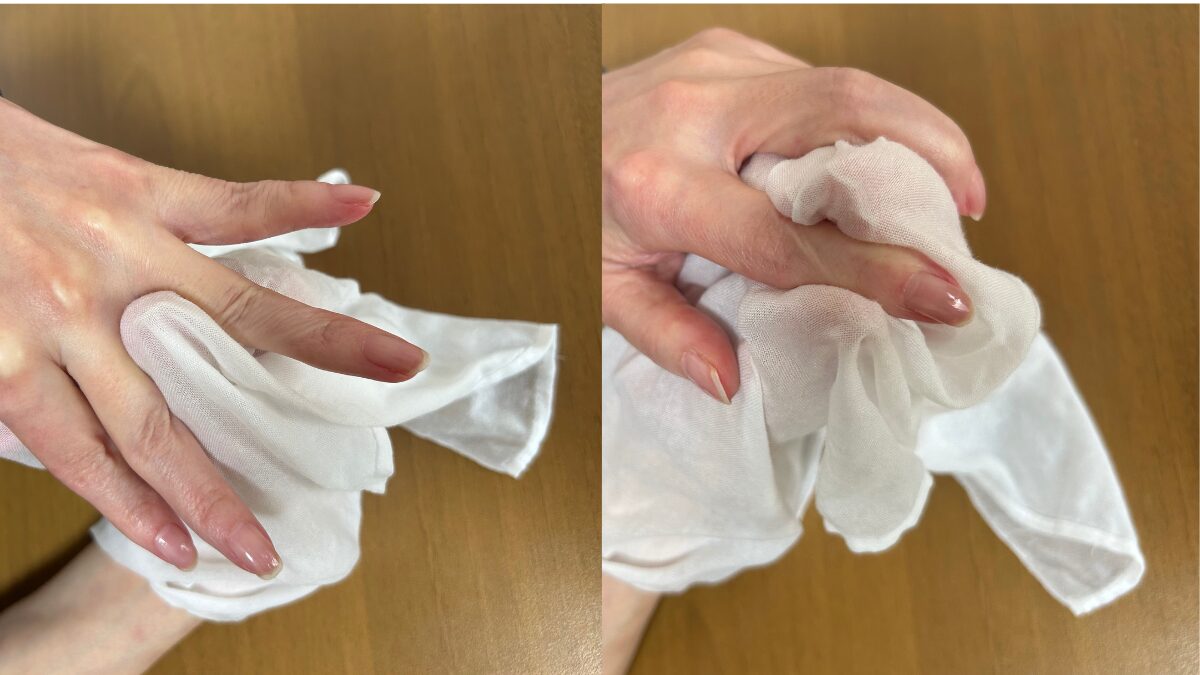 竹布洗顔クロスで左手の指の間を拭いている様子
