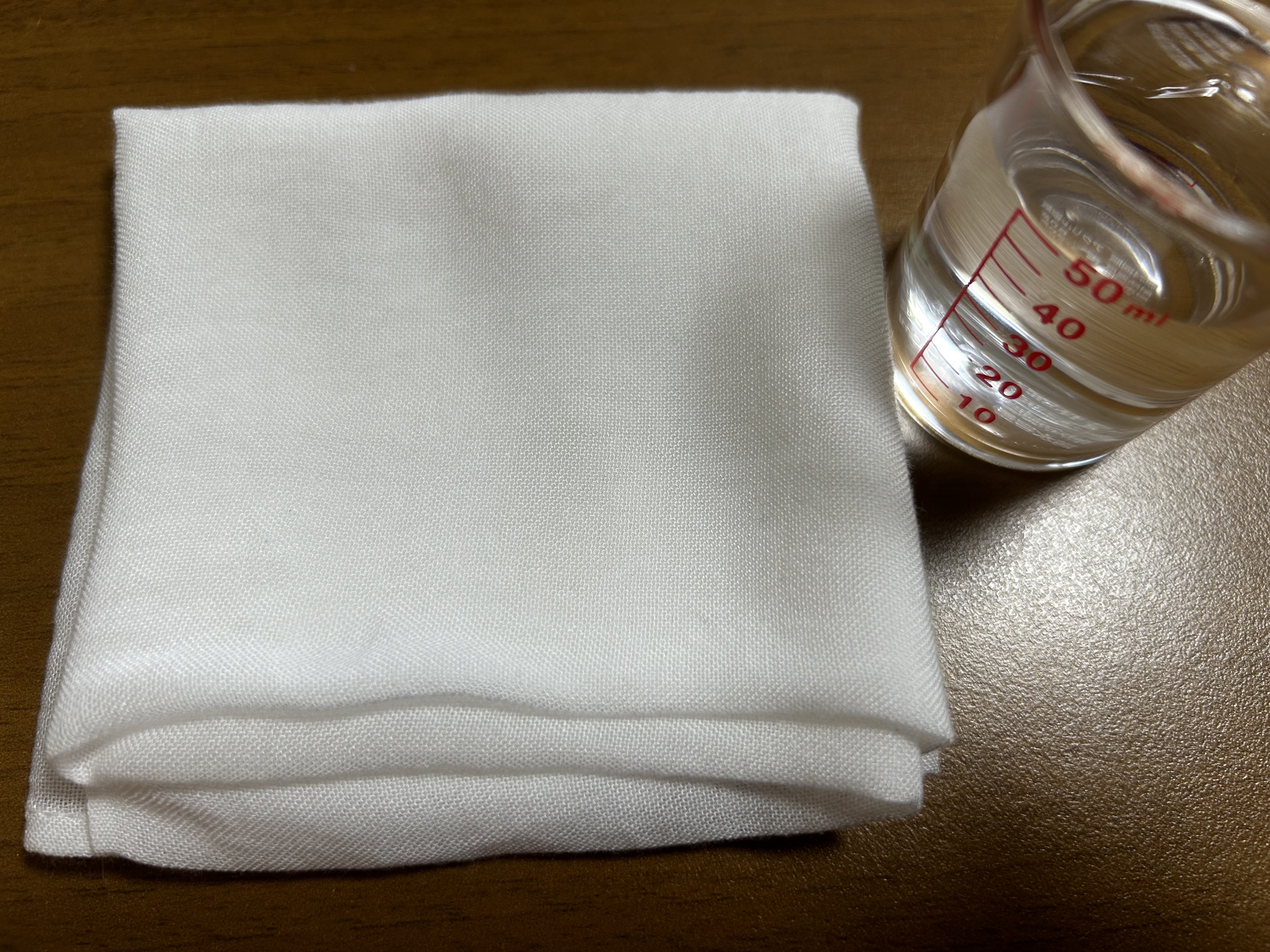 竹布洗顔クロスと計量カップに水50cc